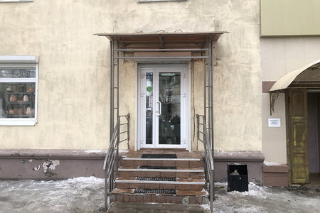 Навес над входом в здание с колоннами и перилами